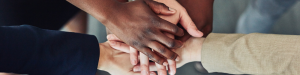 group of people placing there hands on top of another.