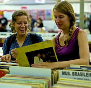 A women discussing and selecting a vinyl record
